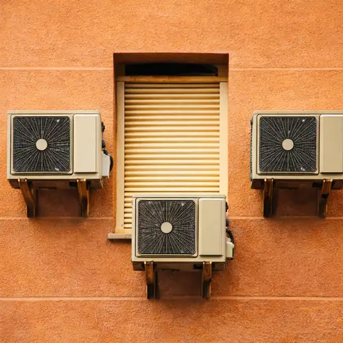 وحدات تكييف خارجية مثبتة على جدار مبنى مع قواعد تثبيت واضحة